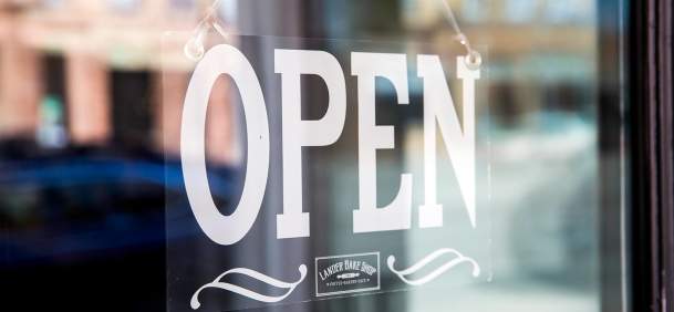 Open sign hanging inside of a window.